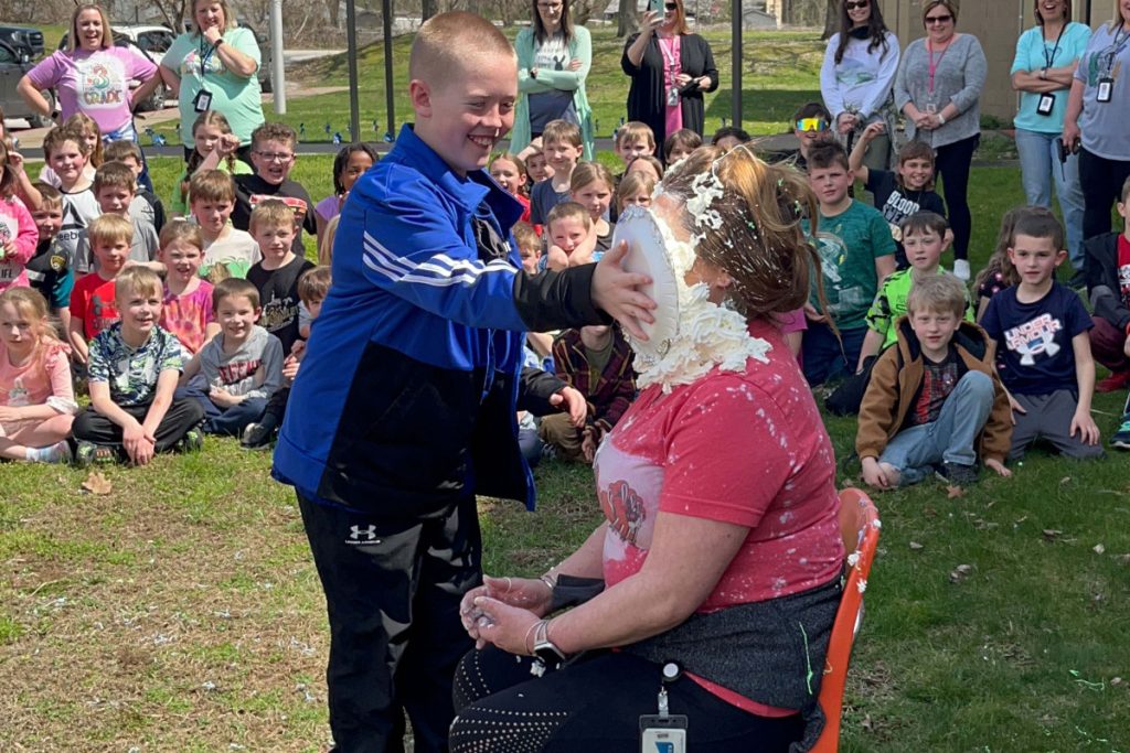 Cutline: WLES 5th grader Blake Yoho smashes a pie in WLES Principal Julie Sturgill’s face as a part of the fundraiser celebration. 